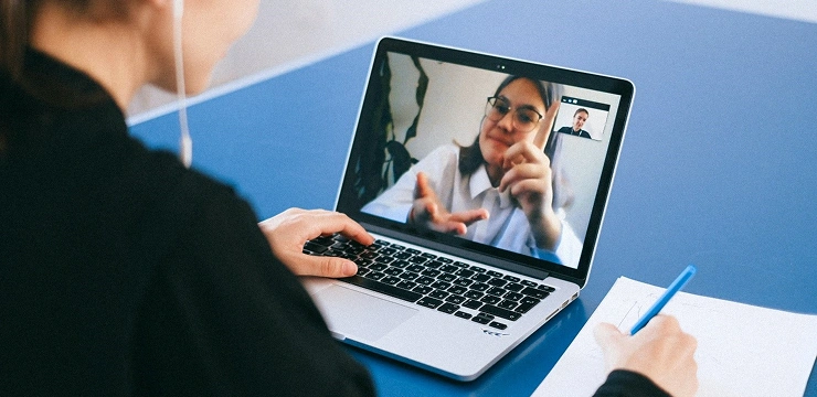 A woman consults with someone through a video call on a laptop.