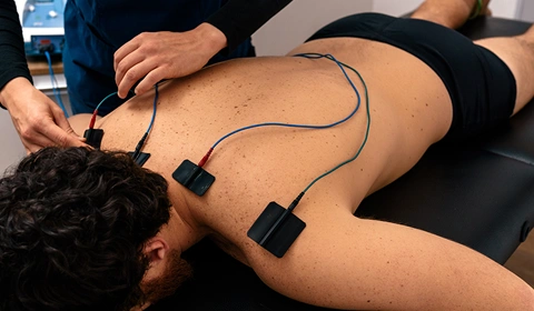 Electrotherapy pads on a man’s back.