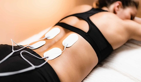 Electrotherapy pads on a woman’s lower back.